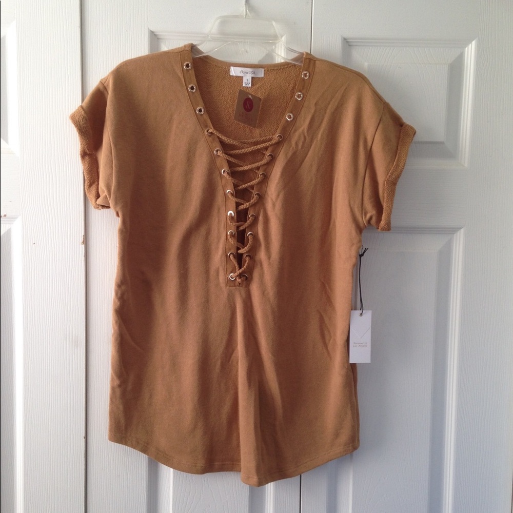 Tan shirt with criss cross design.